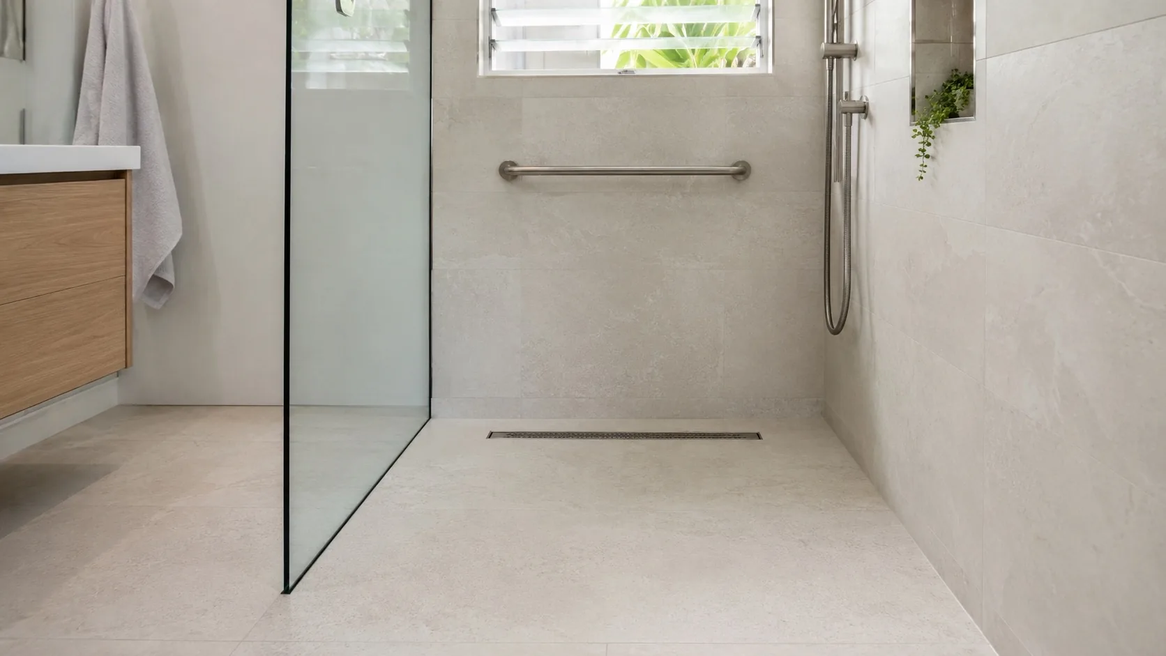 Modern accessible bathroom with level-entry shower and grab rail in a Brisbane home
