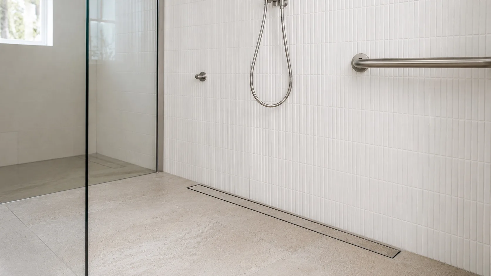 Hobless shower with level entry, linear drain and handheld shower rail